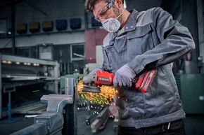 Person schneidet Metall mit Winkelschleifer